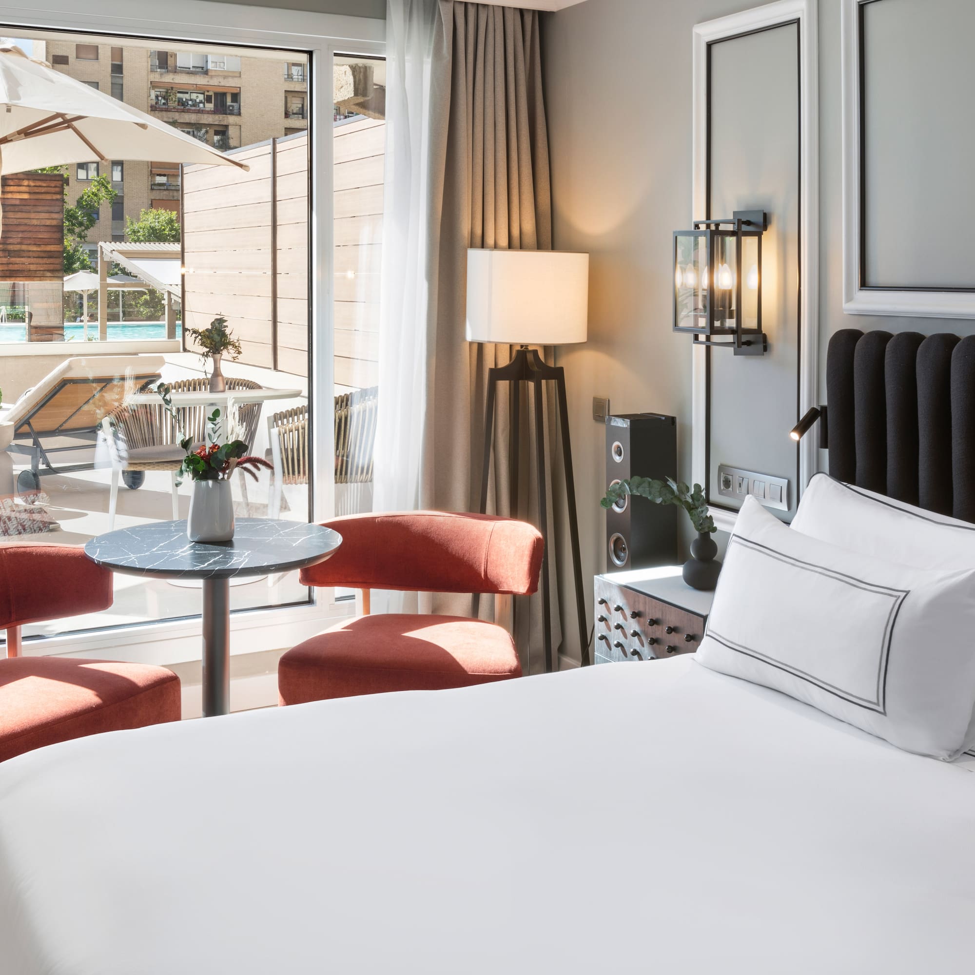 a room with a bed and chairs