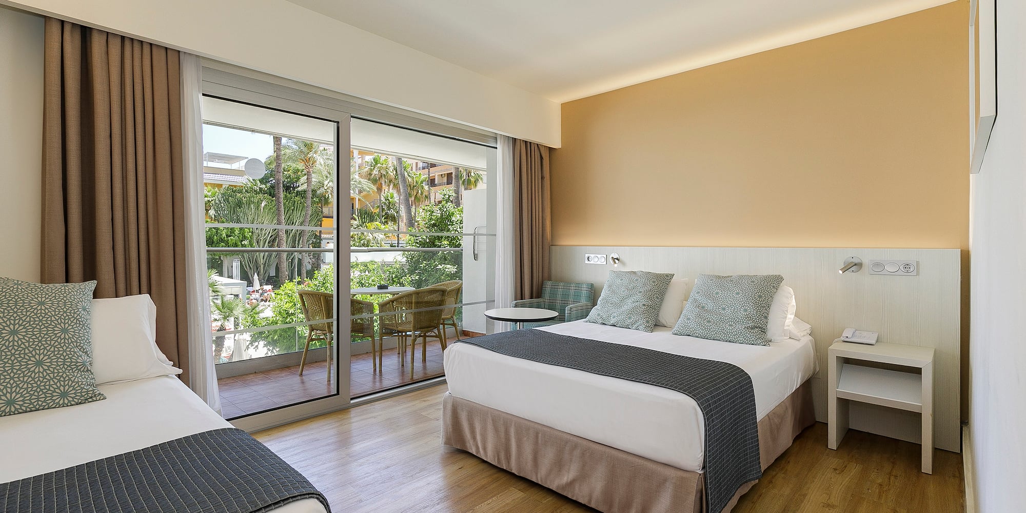 a room with two beds and a glass door