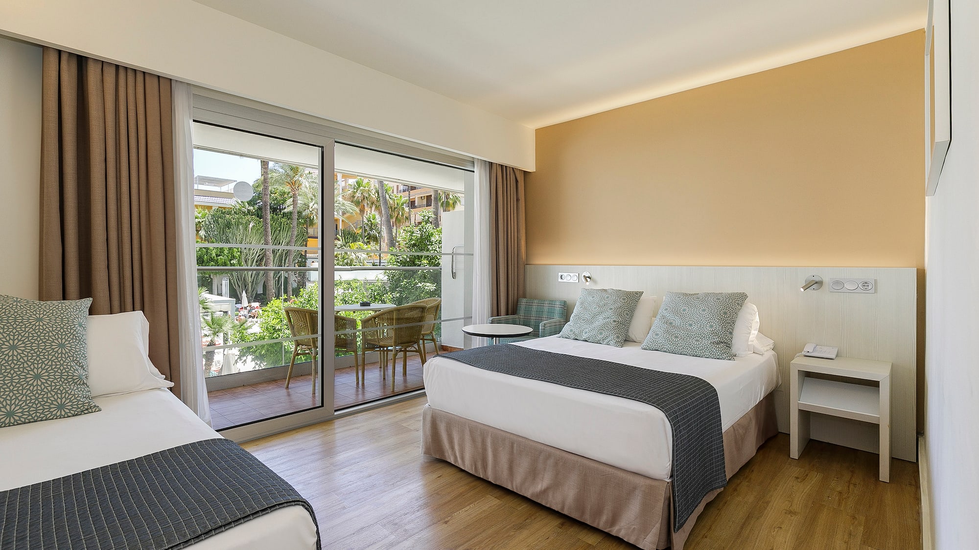 a room with two beds and a glass door