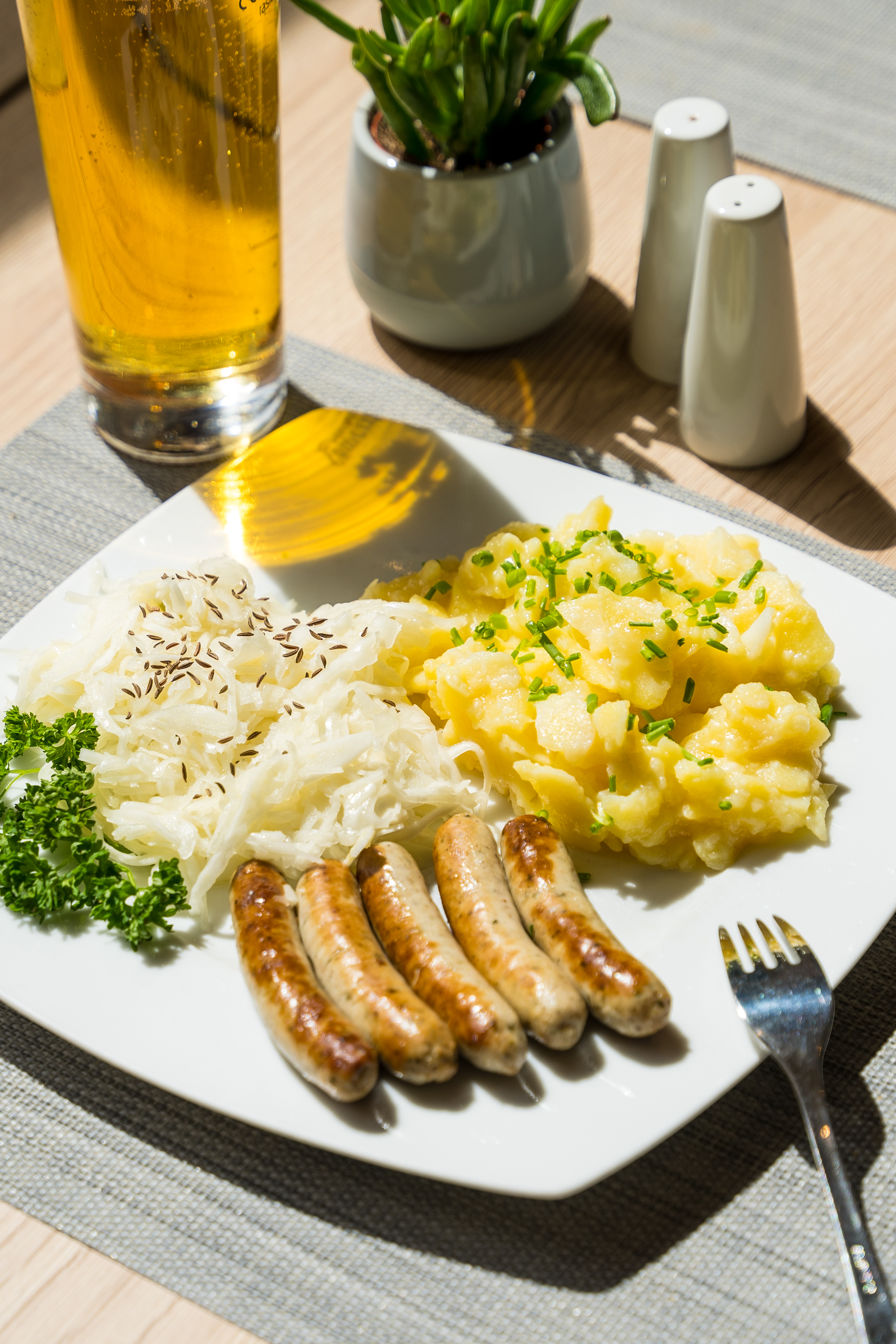 Grilled sausages, sauerkraut, mashed potatoes, and a beer.