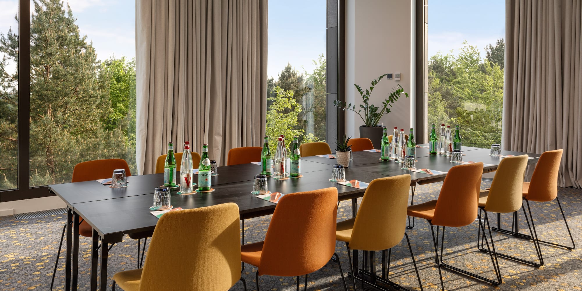a table with bottles on it and chairs in front of windows