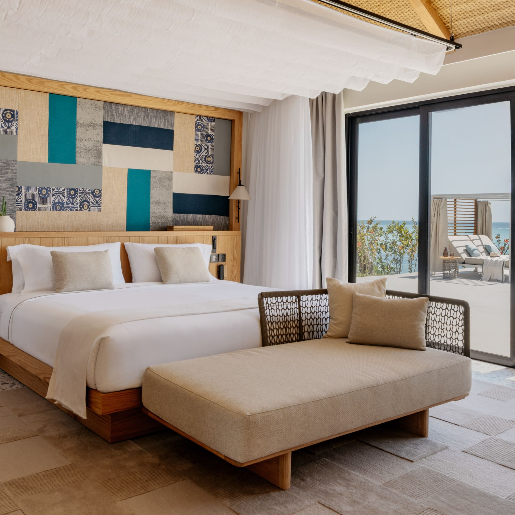 a bedroom with a bed and a chaise lounge