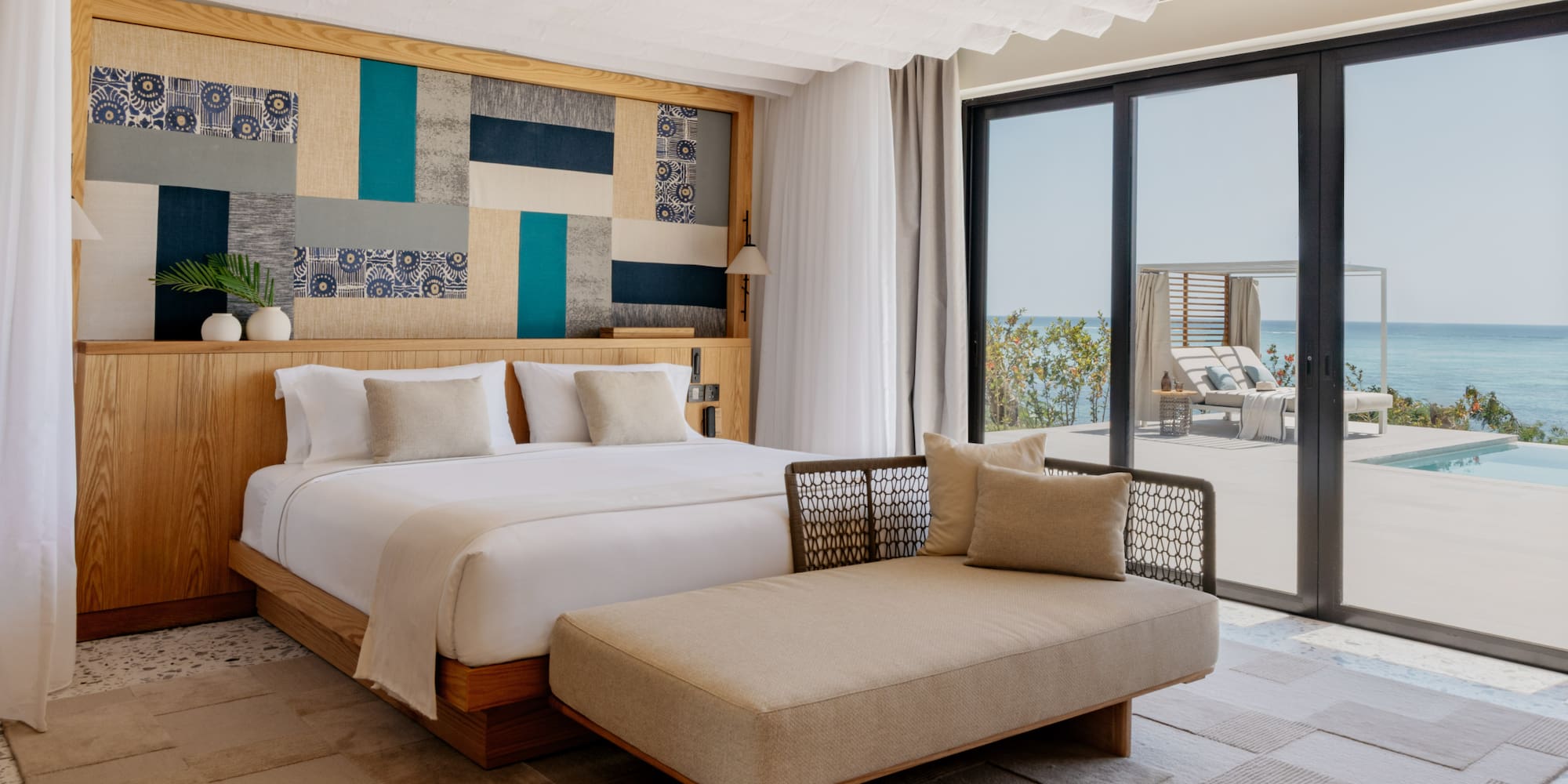 a bedroom with a bed and a chaise lounge