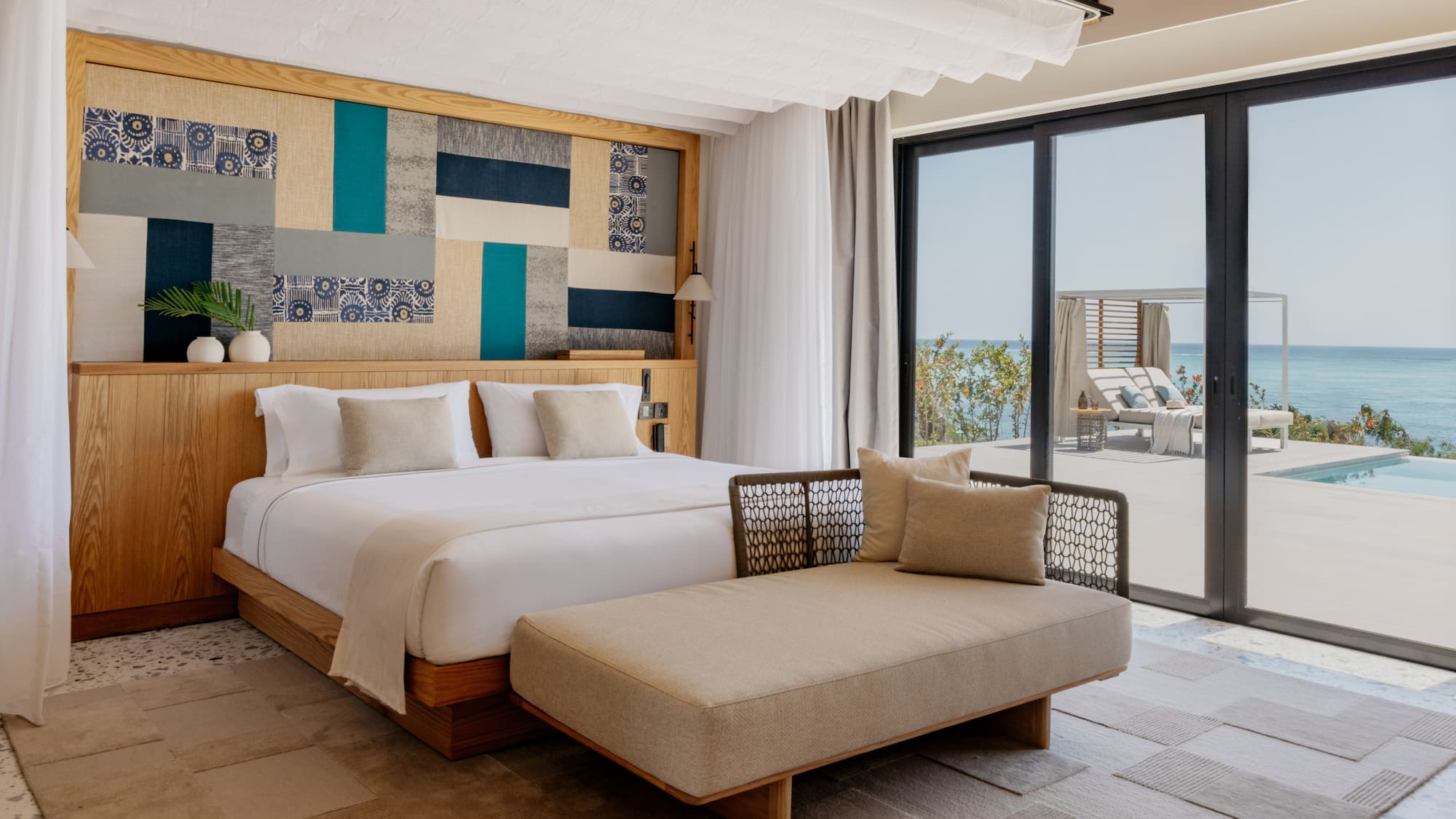 a bedroom with a bed and a chaise lounge