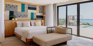 a bedroom with a bed and a chaise lounge