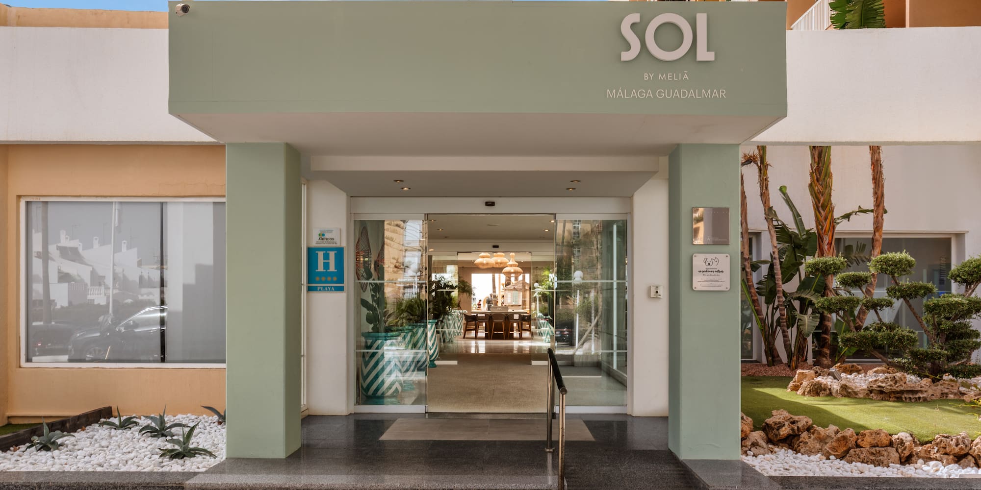 Sol by Meliá Málaga Guadalmar 4-star hotel entrance with glass doors and lush landscaping.