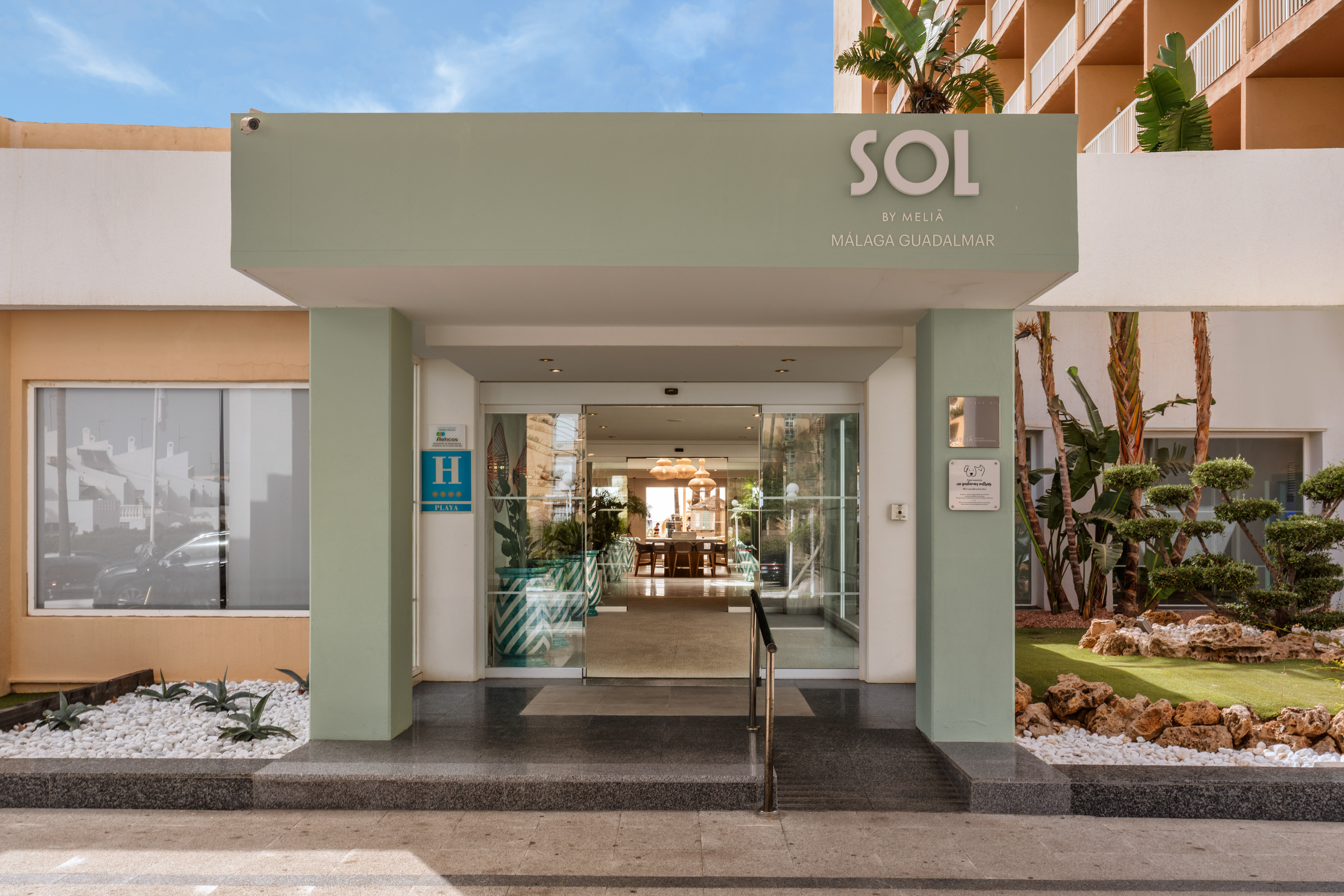 Sol by Meliá Málaga Guadalmar 4-star hotel entrance with glass doors and lush landscaping.