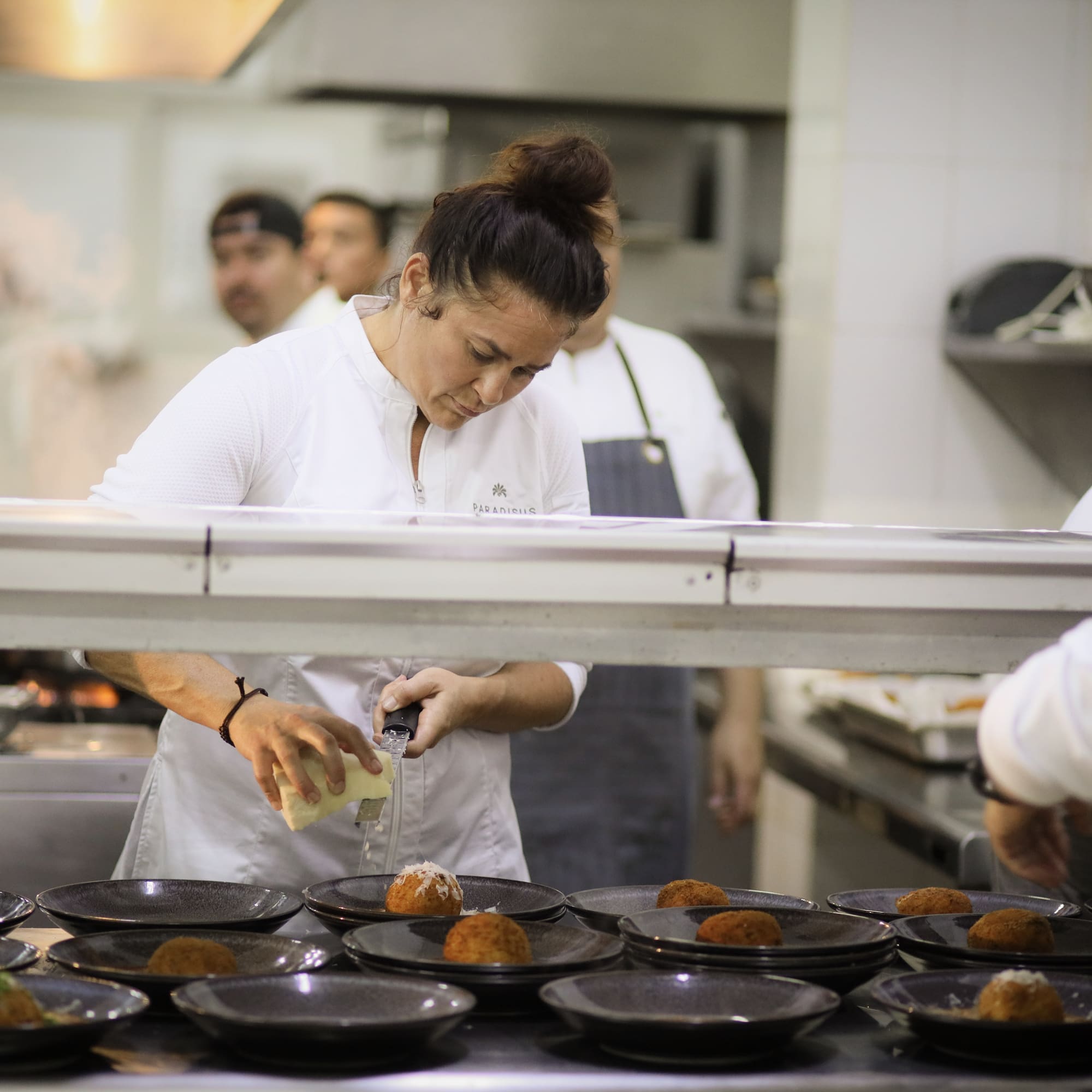 a woman pouring liquid into a plate of food