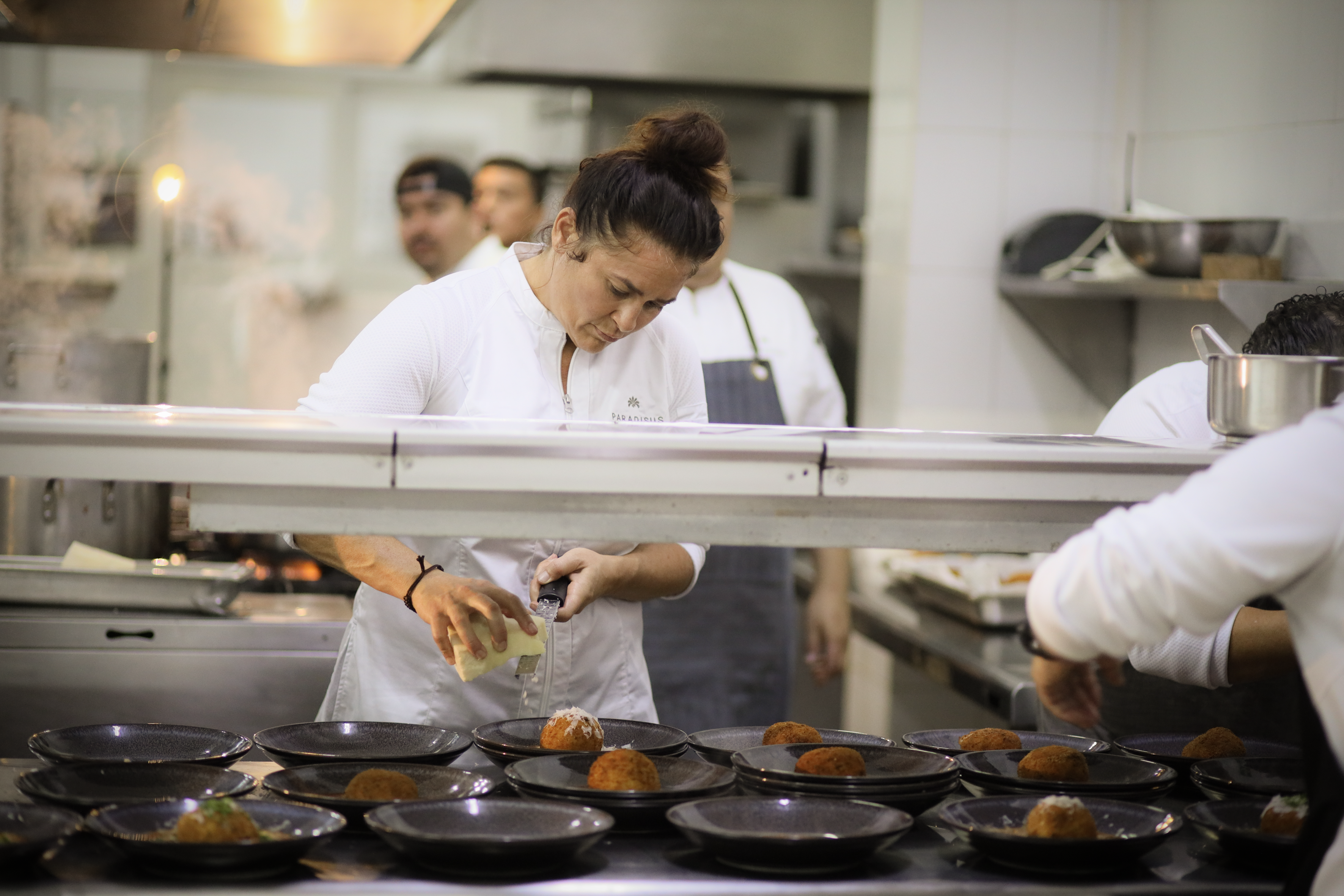 a woman pouring liquid into a plate of food