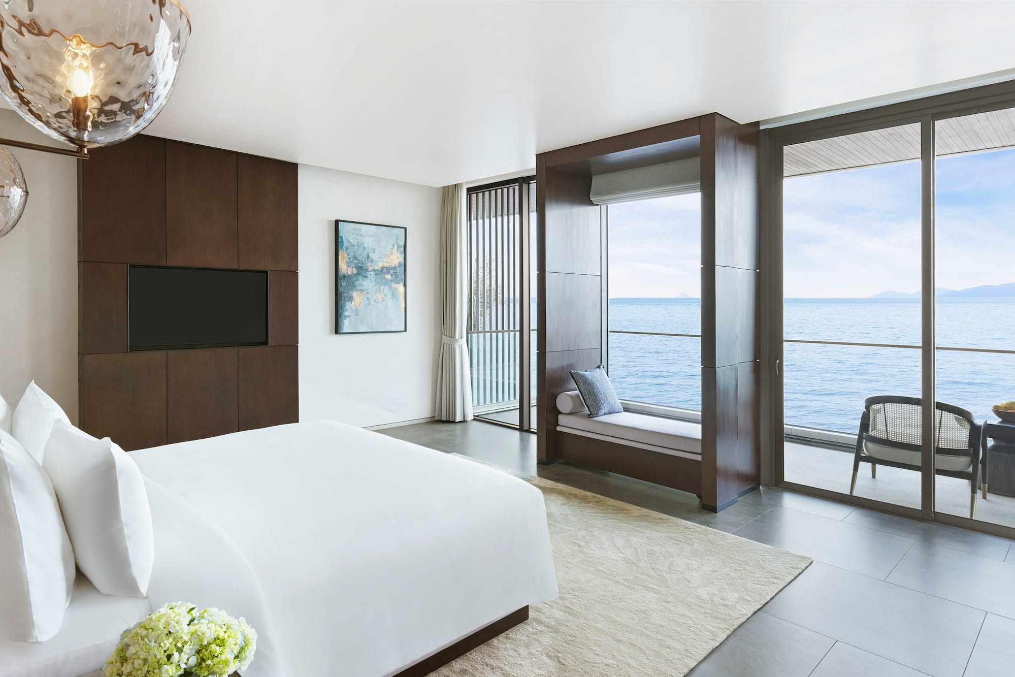 a bedroom with a large window overlooking the ocean