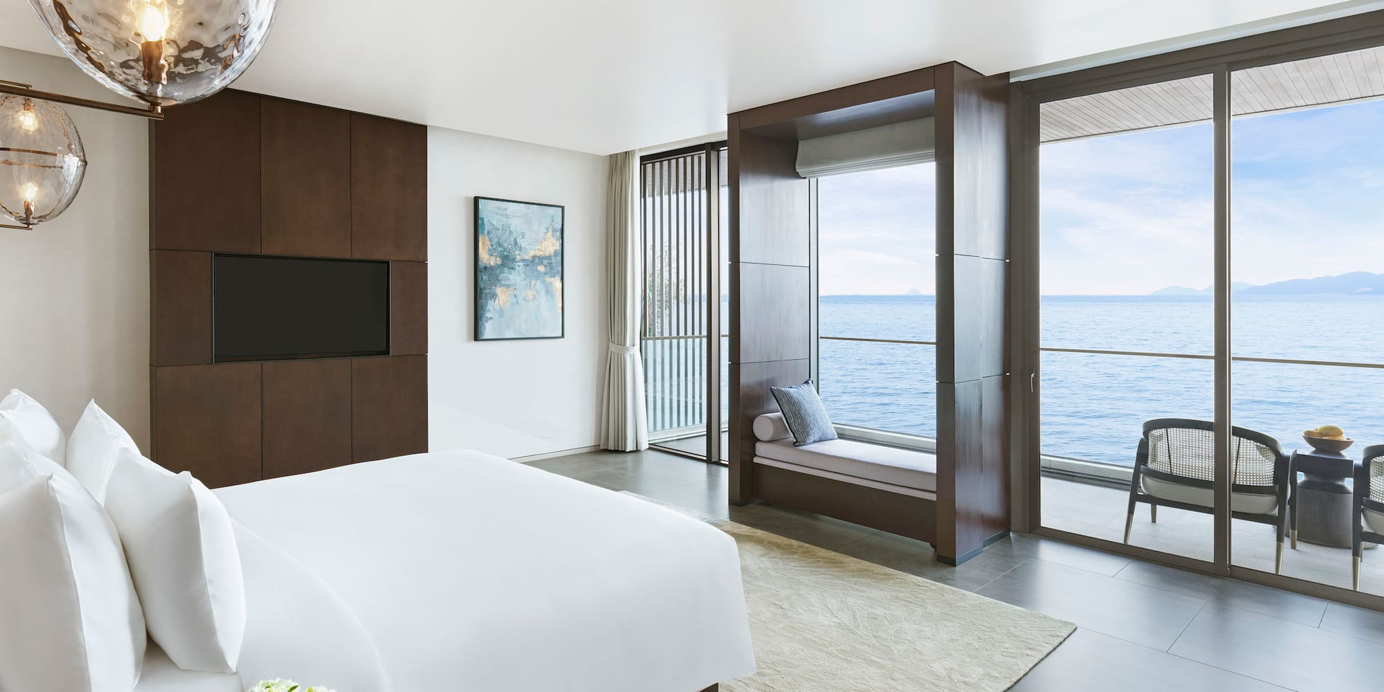 a bedroom with a large window overlooking the ocean