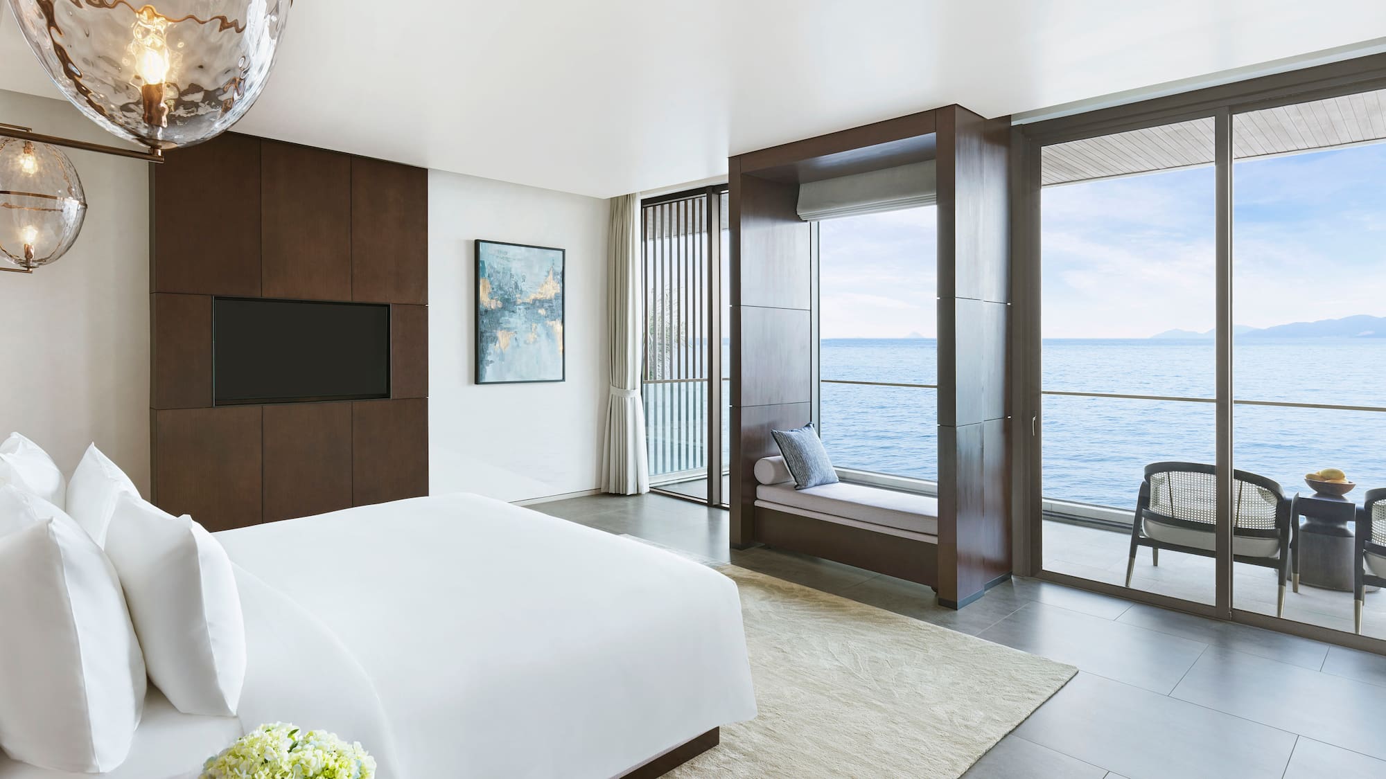 a bedroom with a large window overlooking the ocean