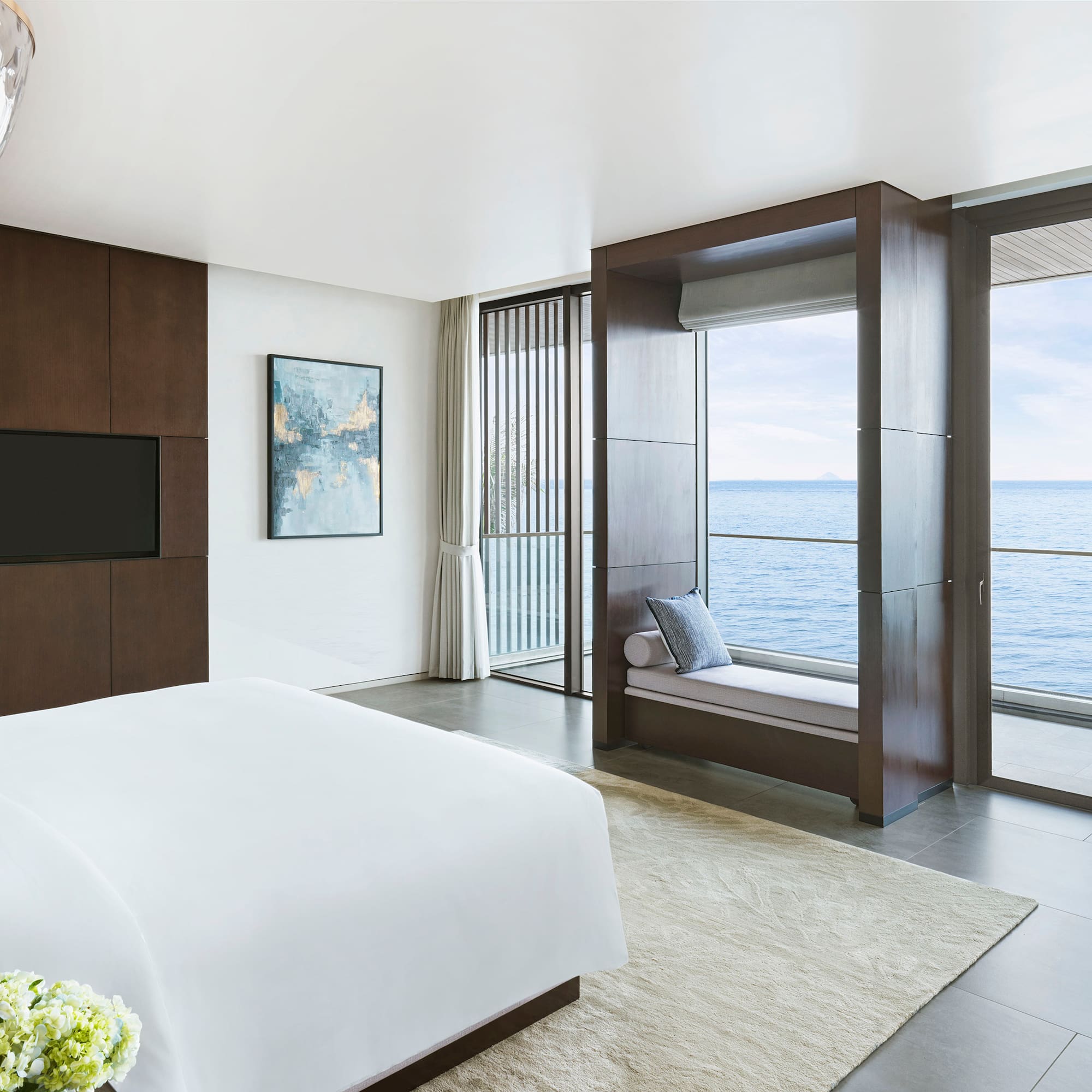 a bedroom with a large window overlooking the ocean
