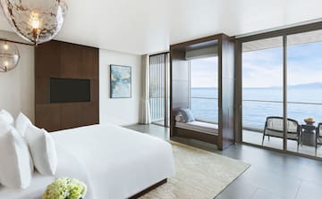 a bedroom with a large window overlooking the ocean