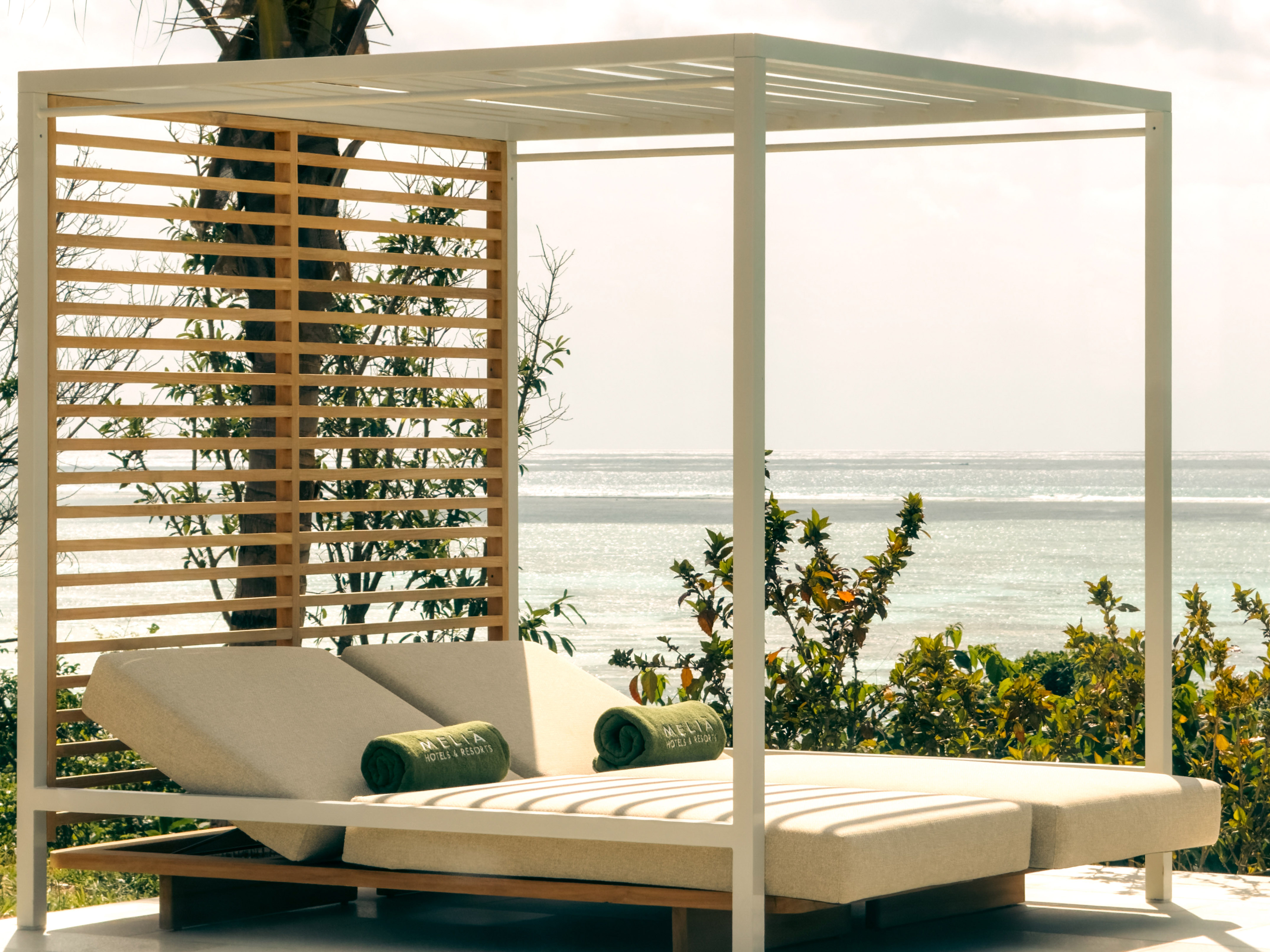 White resort cabana with daybeds, Meliá towels, and ocean view.