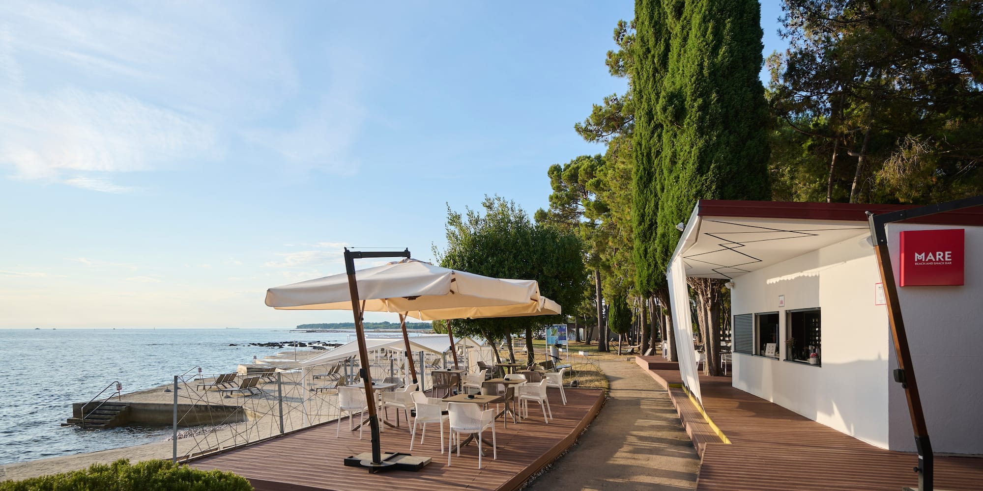 a building with a table and umbrella on a beach