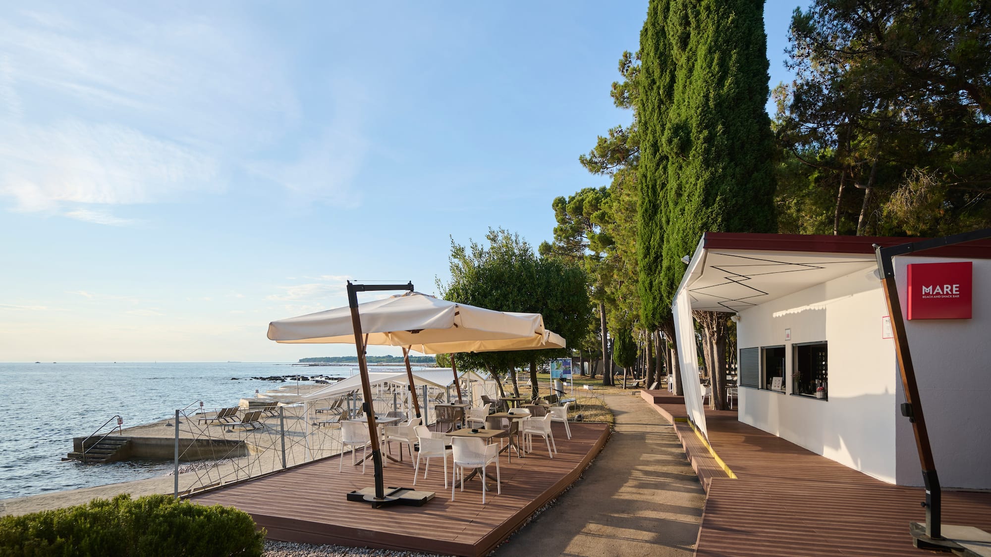 a building with a table and umbrella on a beach