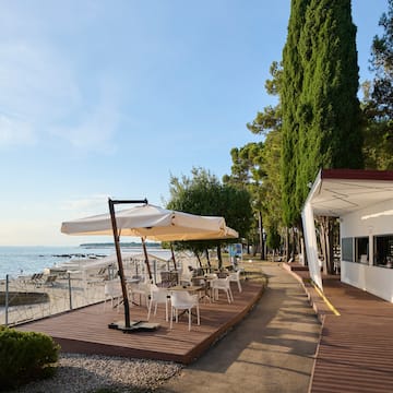 a building with a table and umbrella on a beach
