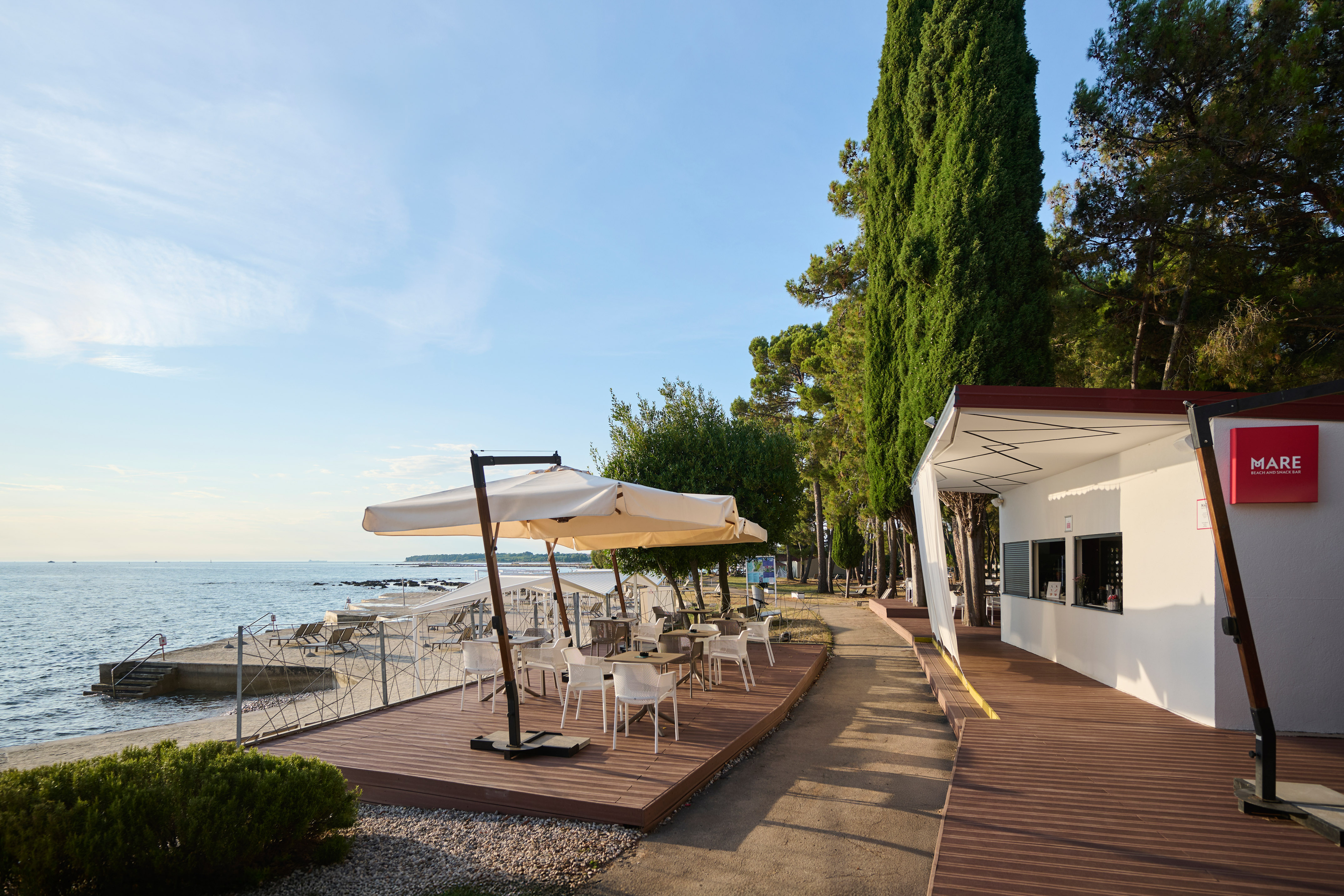 a building with a table and umbrella on a beach