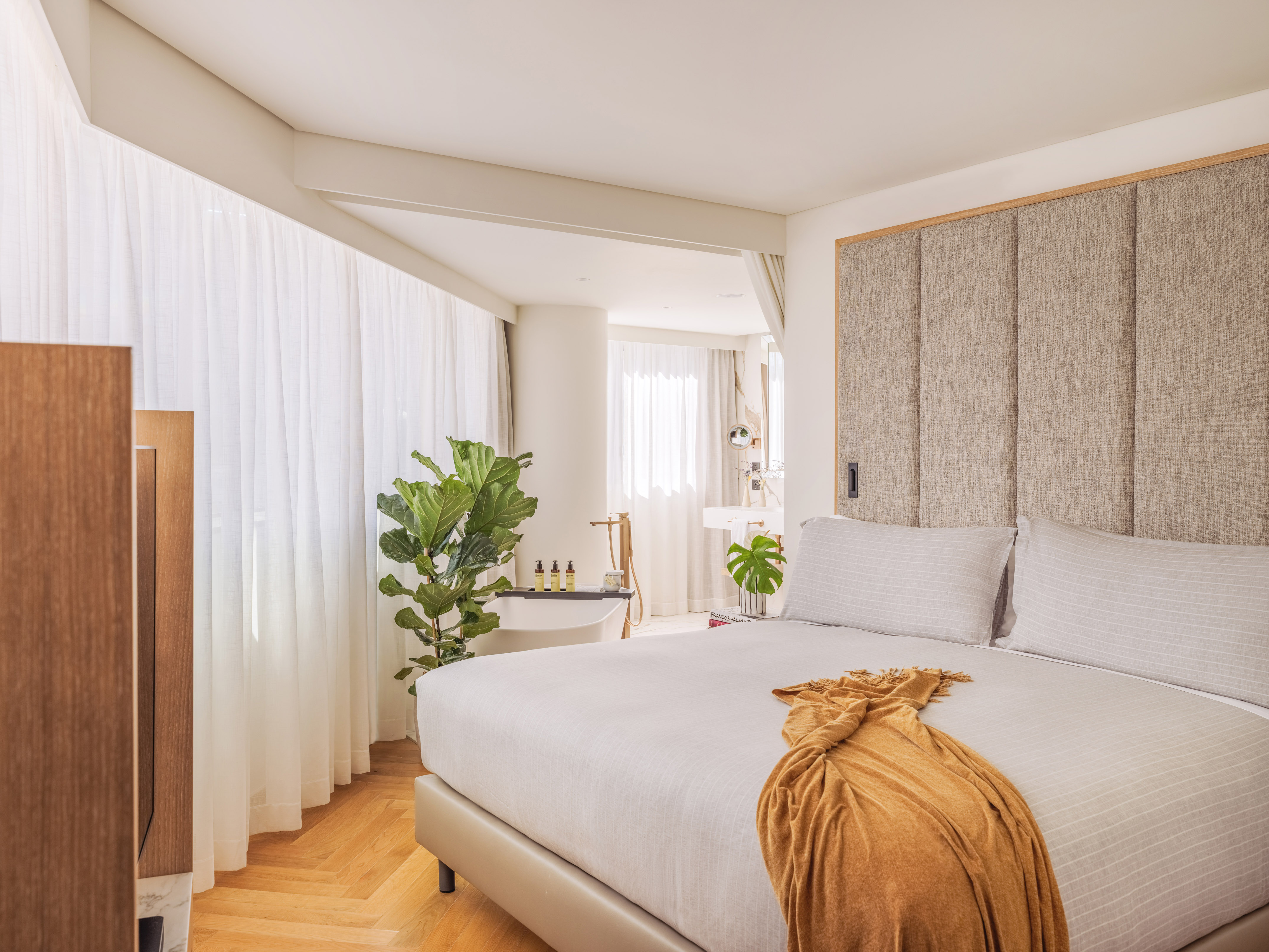 a bedroom with a bed and a plant