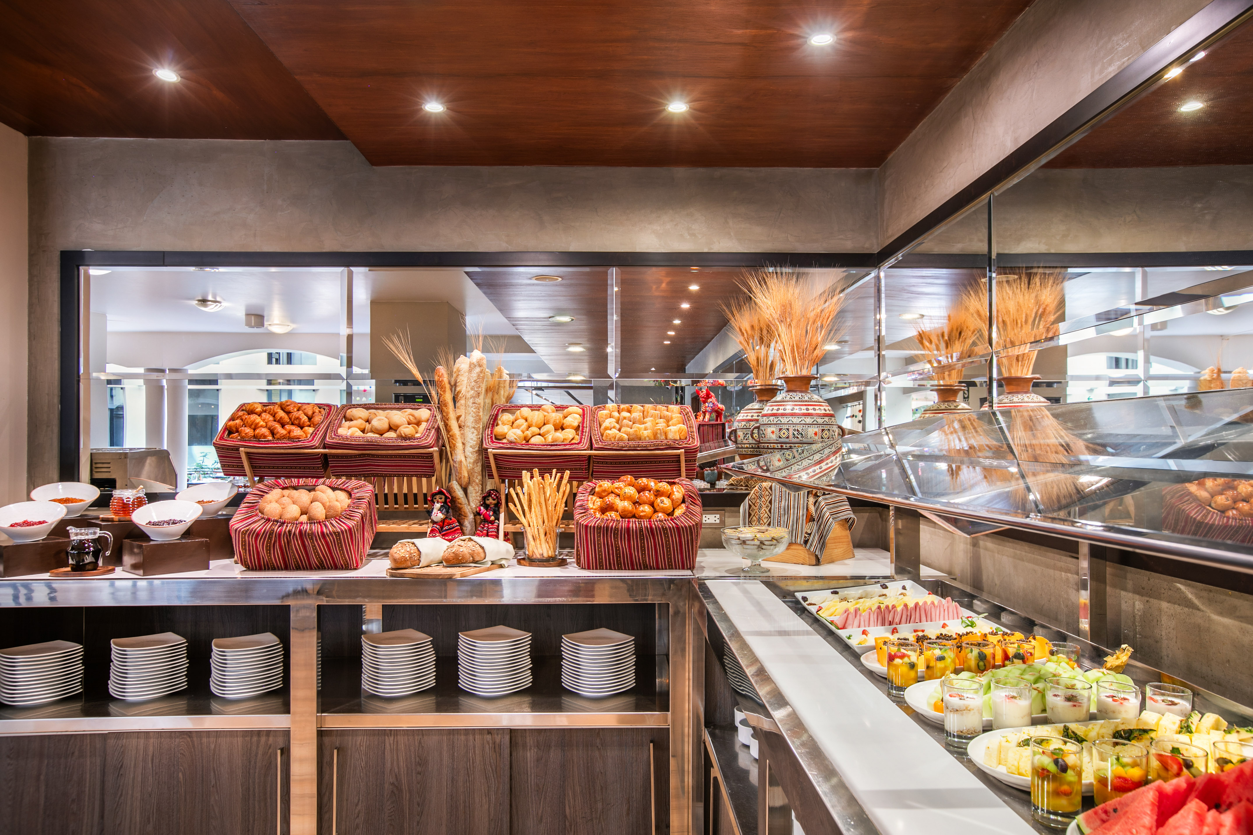 Hotel breakfast buffet with fresh bread, pastries, and fruit cups. - Hotel Cusco La Paccha Affiliated by Meliá, Cusco