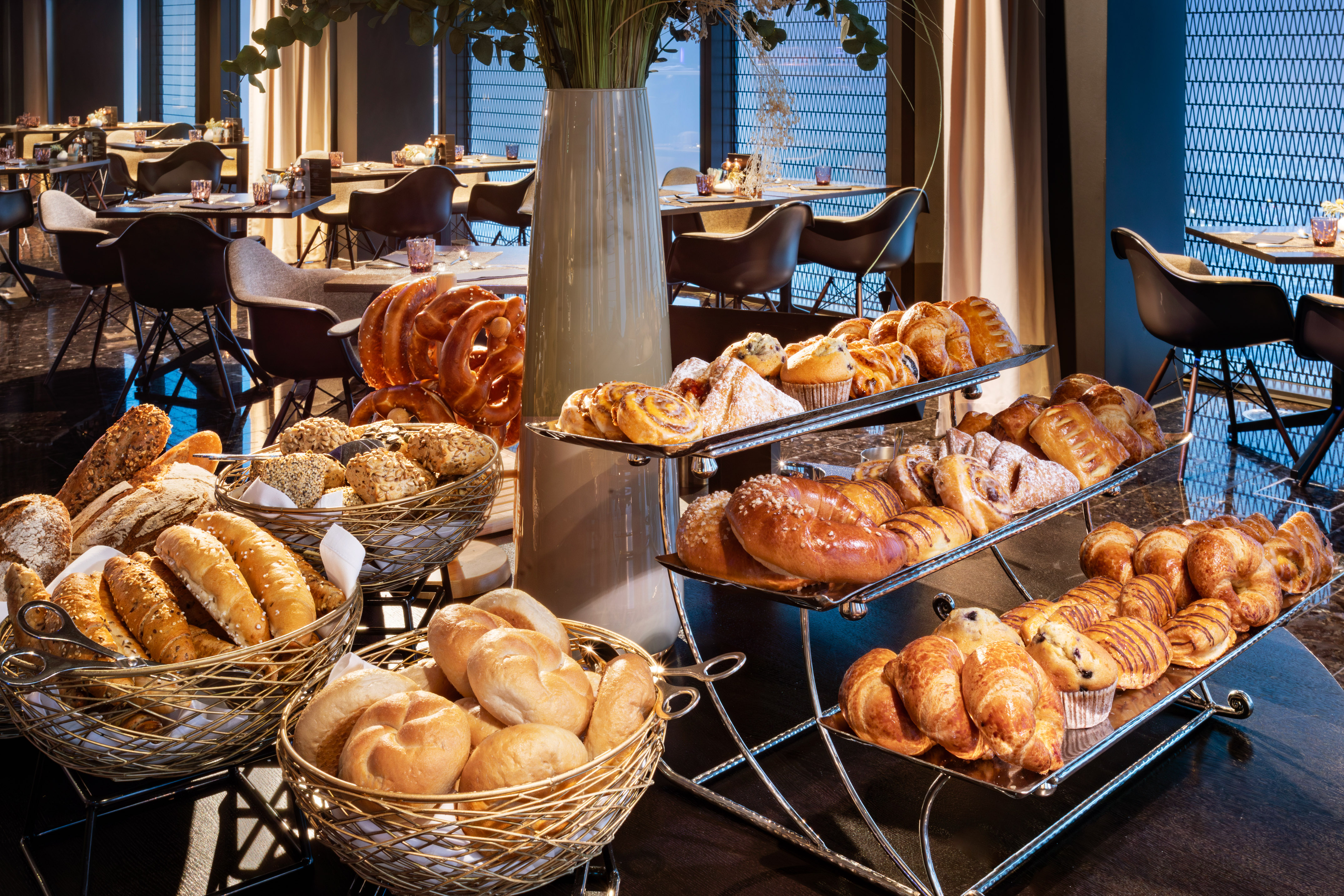 Hotel breakfast buffet with fresh baked goods, breads, pastries, and croissants.