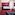 Hotel room with red carpet, pink desk, dark bed, and maroon accent wall.