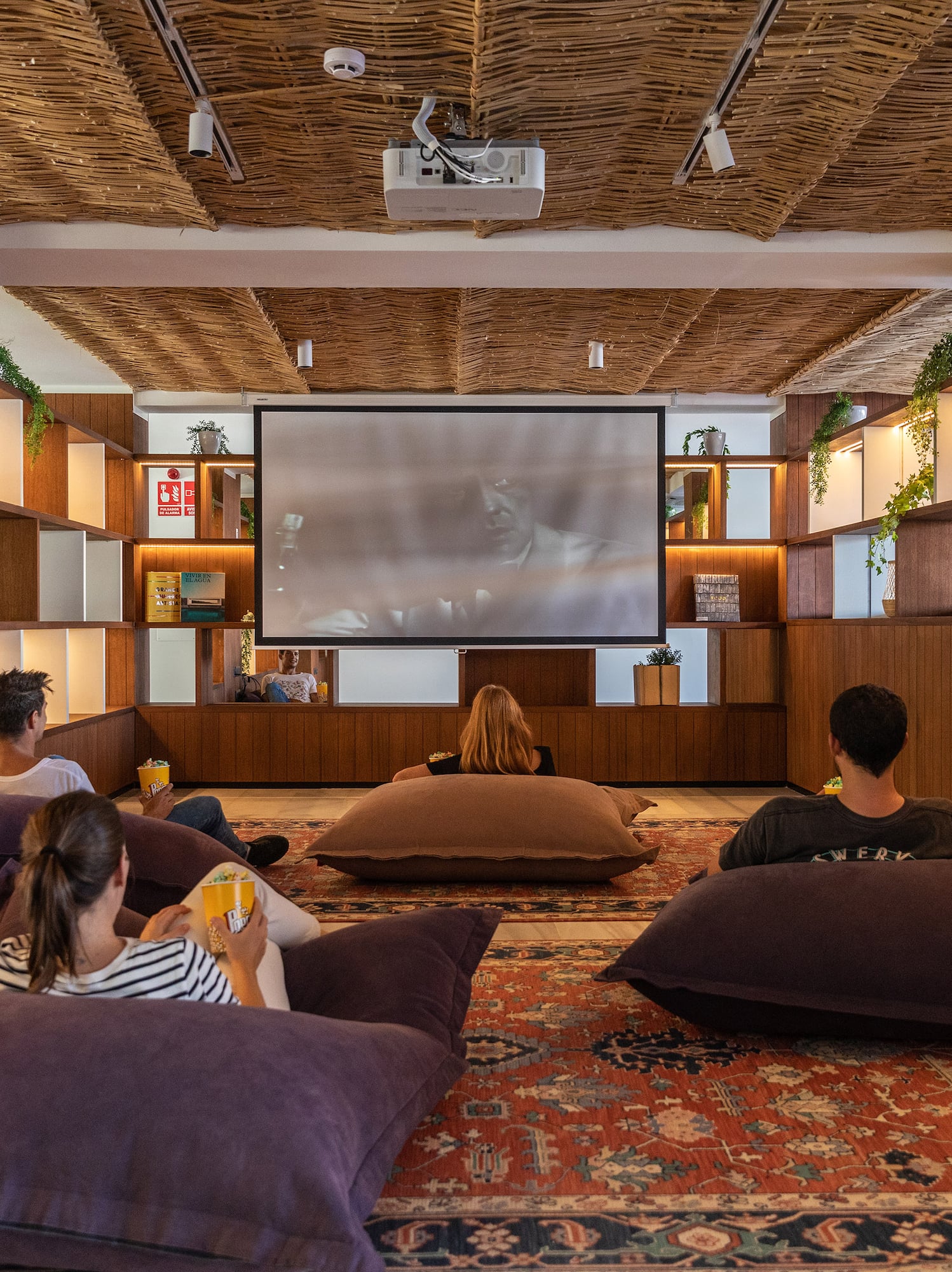 a group of people sitting on pillows in a room with a projector screen