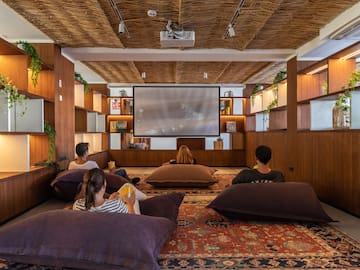 a group of people sitting on pillows in a room with a projector screen
