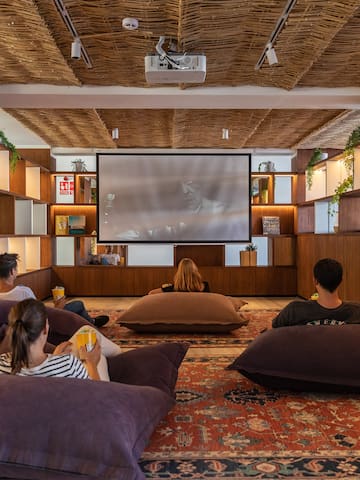 a group of people sitting on pillows in a room with a projector screen