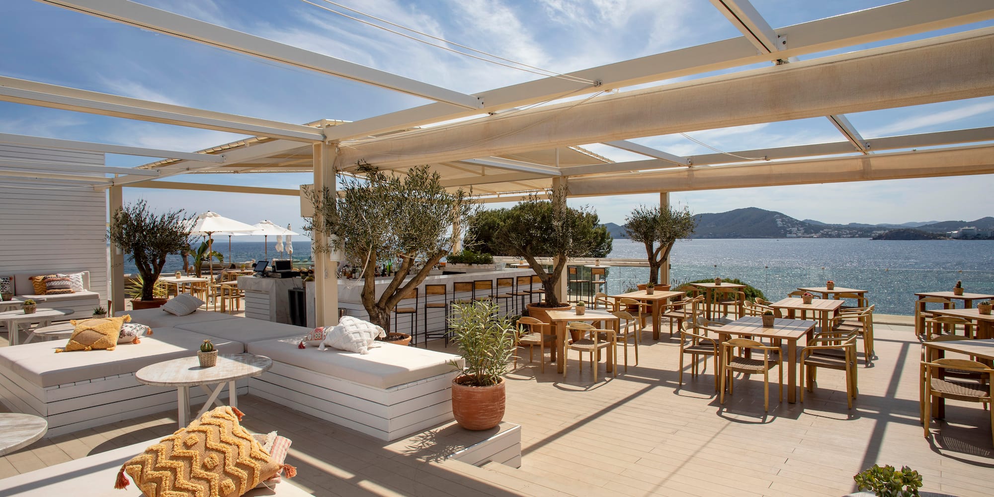 a restaurant with tables and chairs on a deck overlooking the water