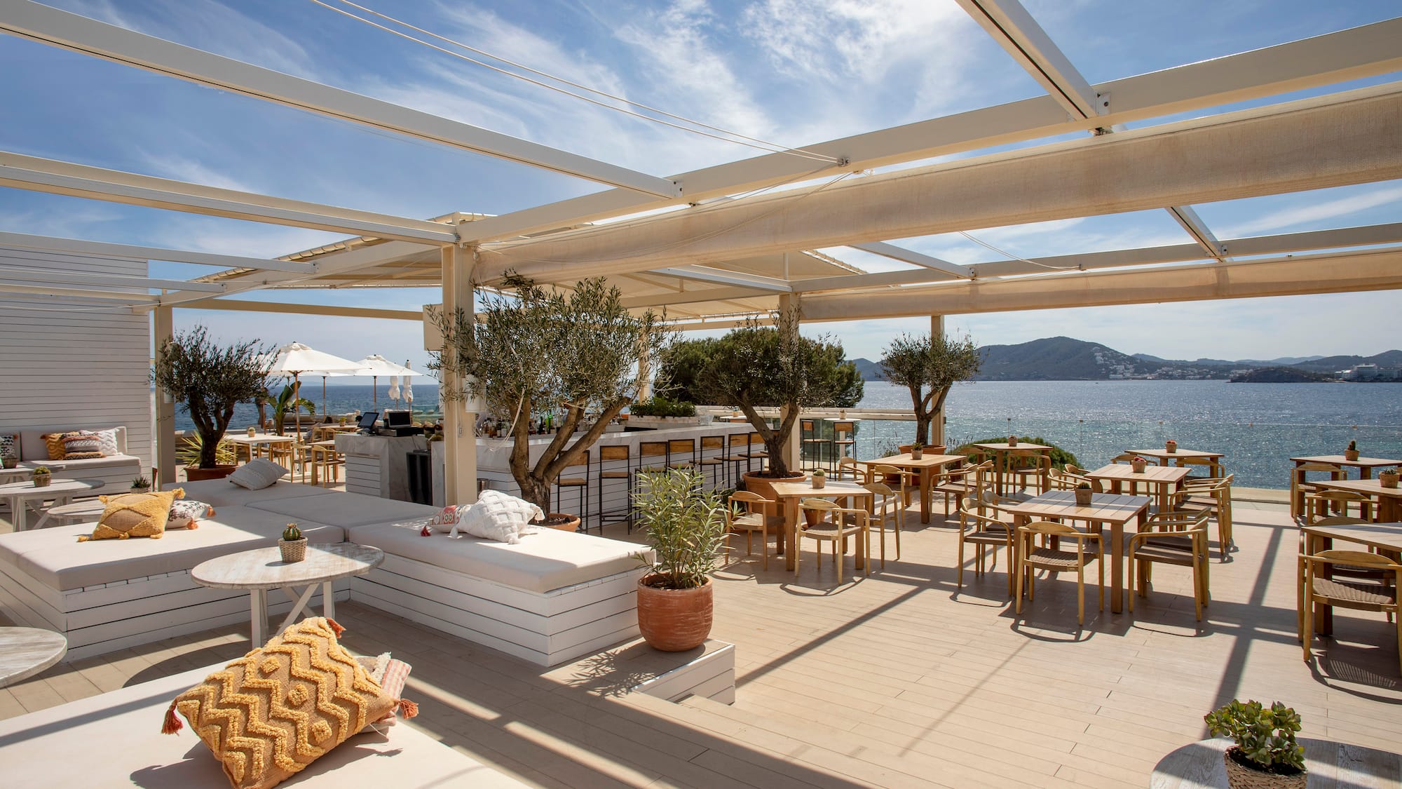a restaurant with tables and chairs on a deck overlooking the water