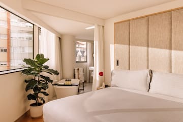 a bedroom with a bed and a plant