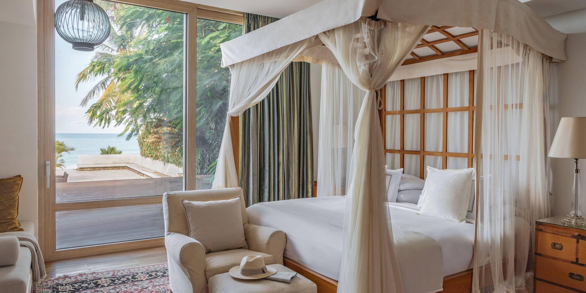 a bedroom with a canopy bed and a chair