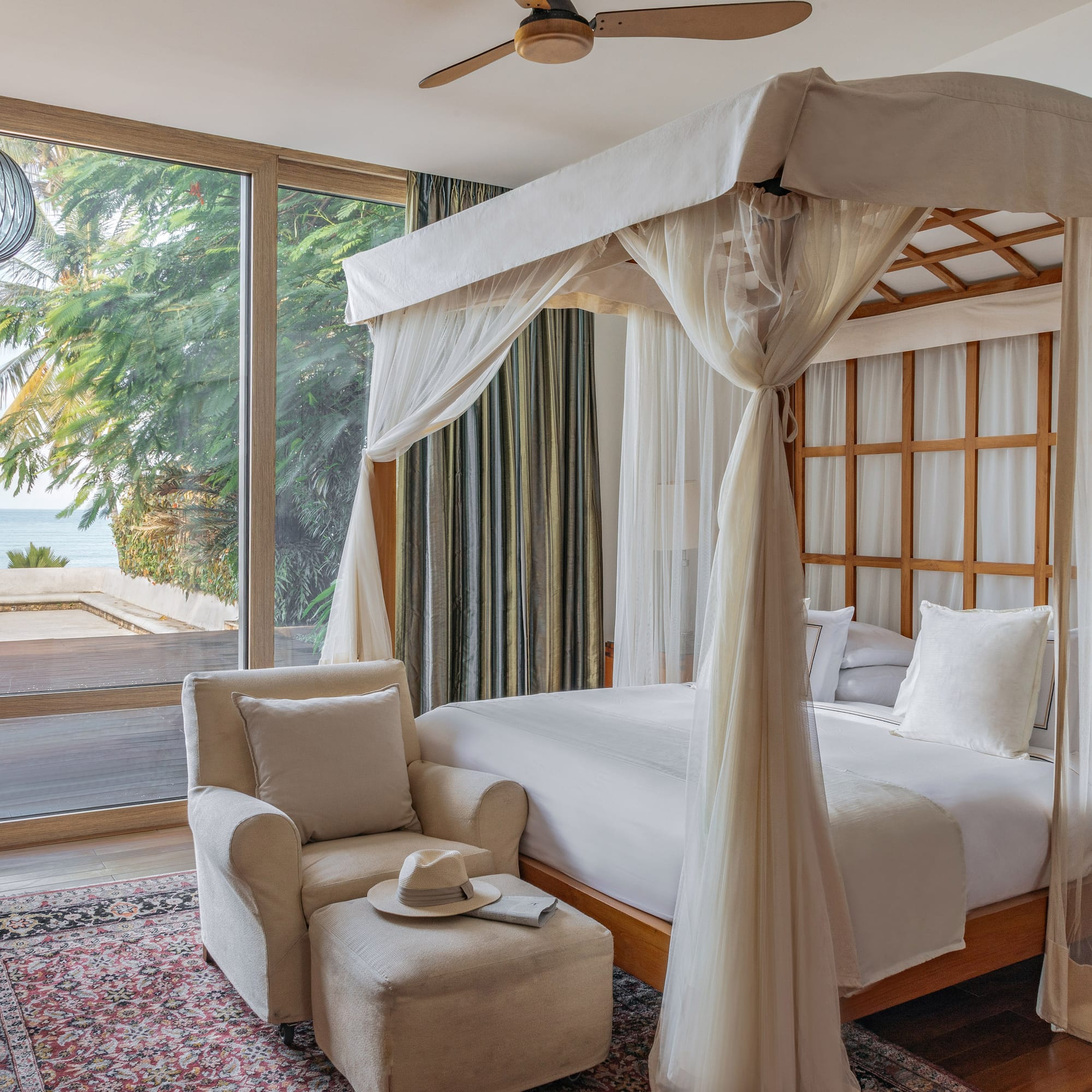 a bedroom with a canopy bed and a chair