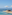 Luxury resort infinity pool with ocean view, sun loungers, and umbrellas.