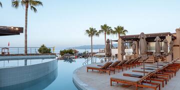 a pool with lounge chairs and umbrellas