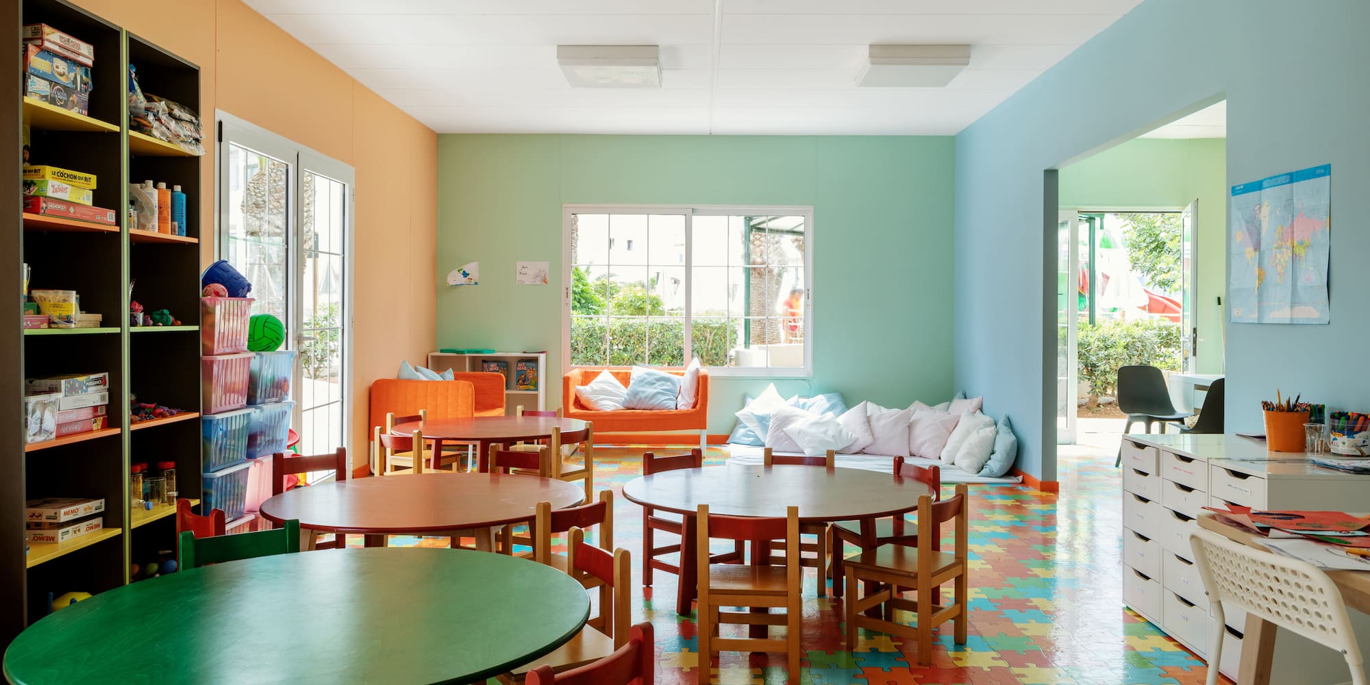 a room with colorful flooring and tables and chairs