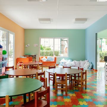 a room with colorful flooring and tables and chairs