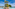 a person standing on a rock in a pool with palm trees