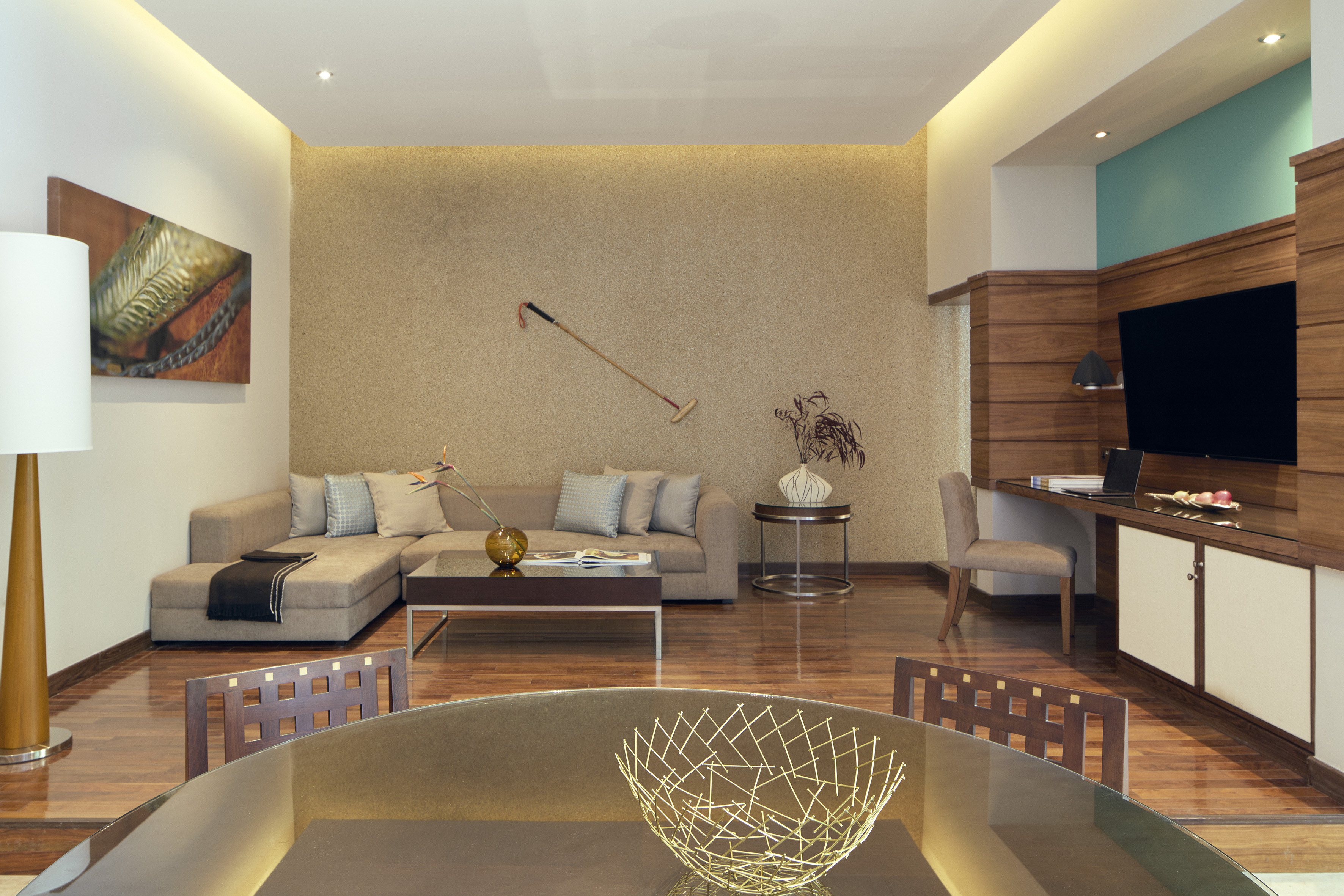Modern living/dining room with sectional sofa, textured wall, wood floors, media center.