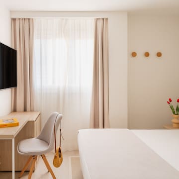 a bedroom with a bed and a desk and a fan