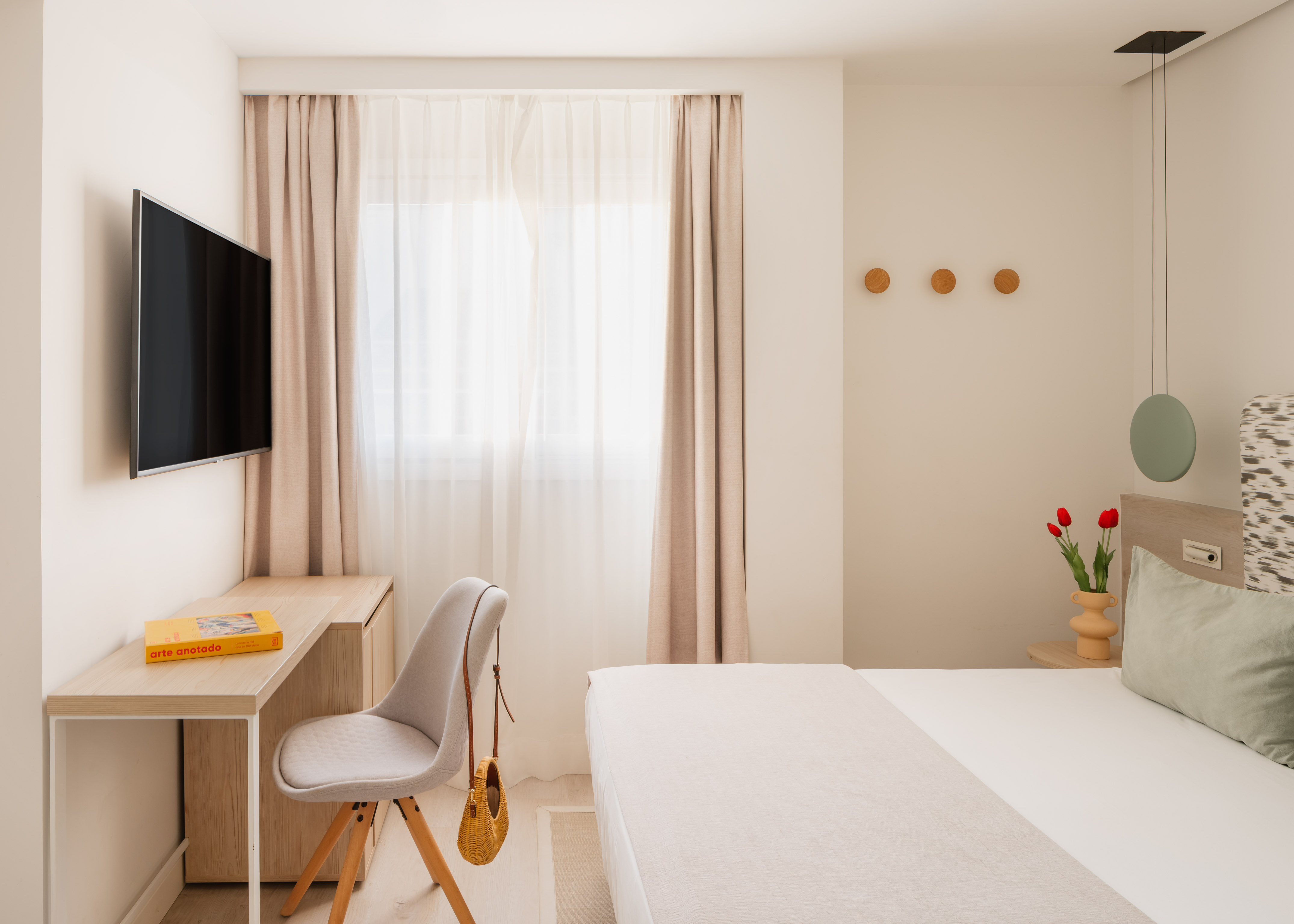 a bedroom with a bed and a desk and a fan