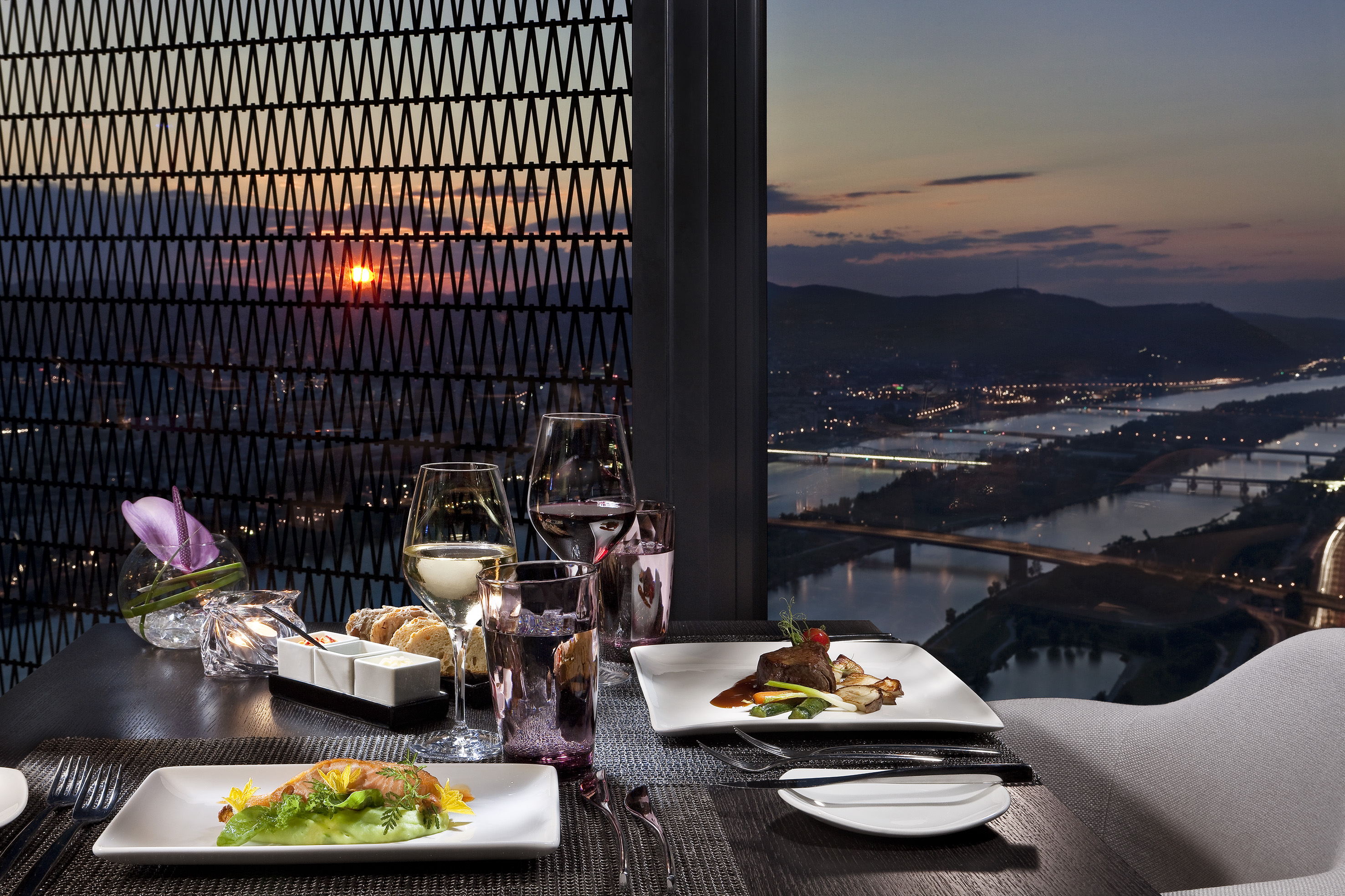 a table with plates of food and glasses of wine