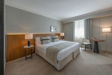 a bedroom with a bed and a table and chairs