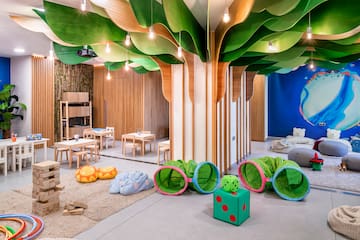 a room with a tree shaped ceiling and a kid's playroom