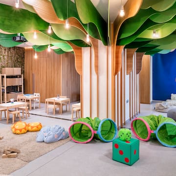 a room with a tree shaped ceiling and a kid's playroom