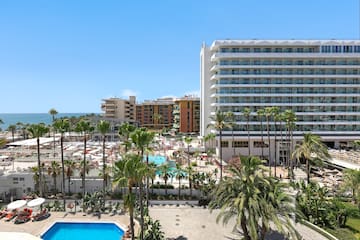 a pool and palm trees next to buildings