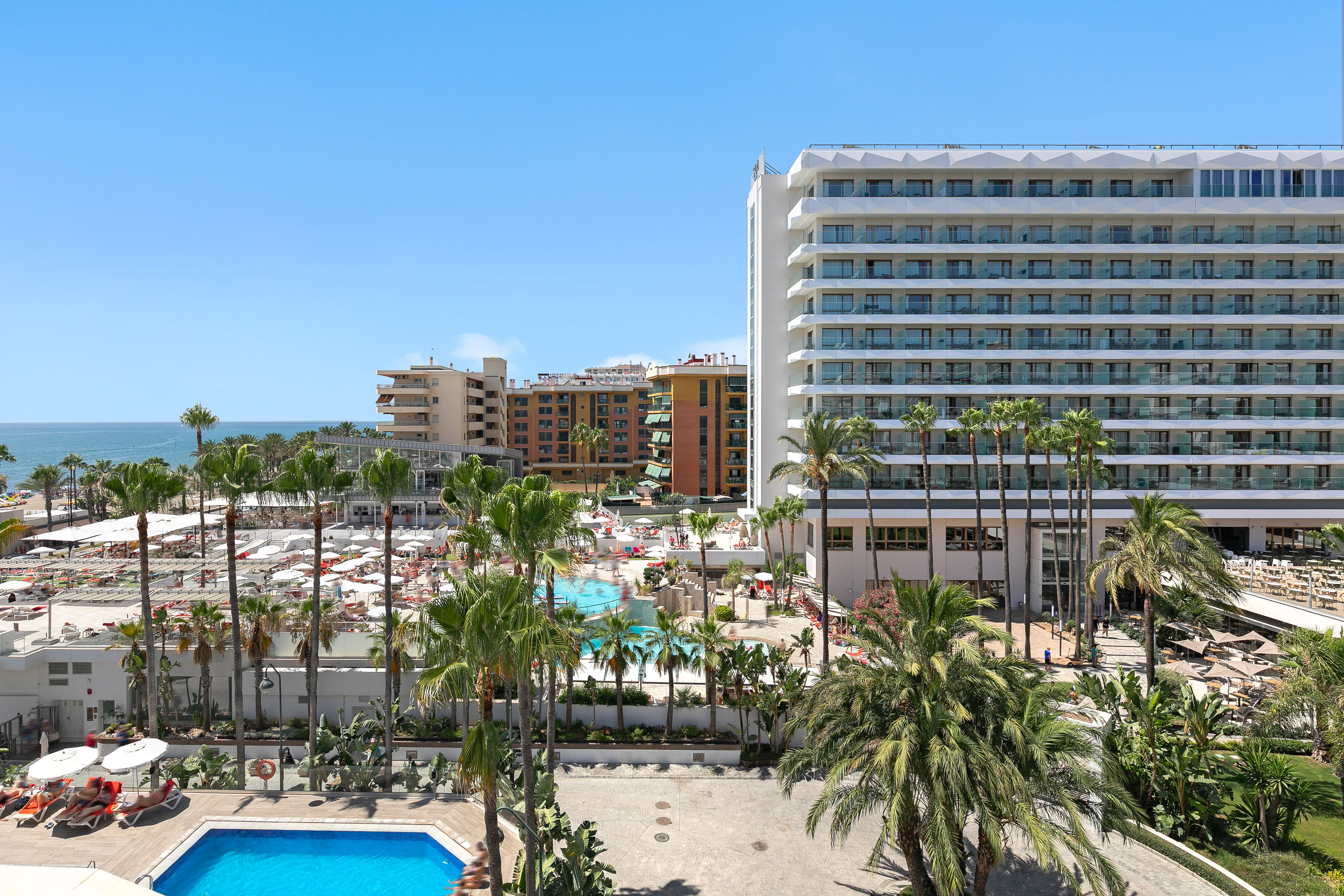 a pool and palm trees next to buildings