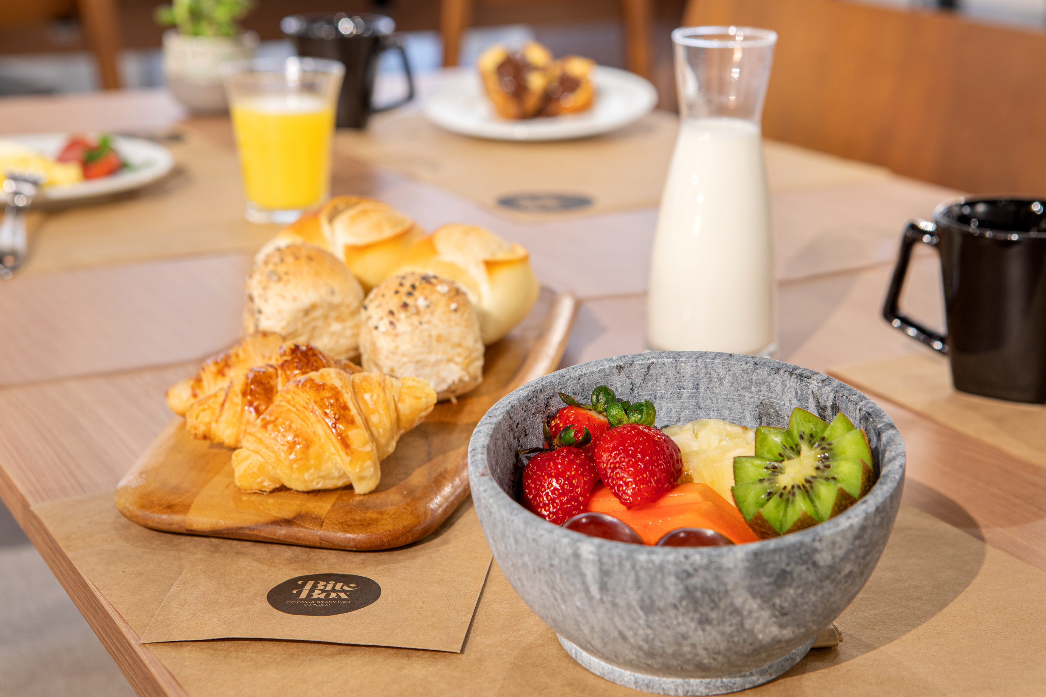 a bowl of fruit and a plate of pastries on a table